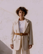 the anchor — woman wearing the camel suede belt over an ecru blazer