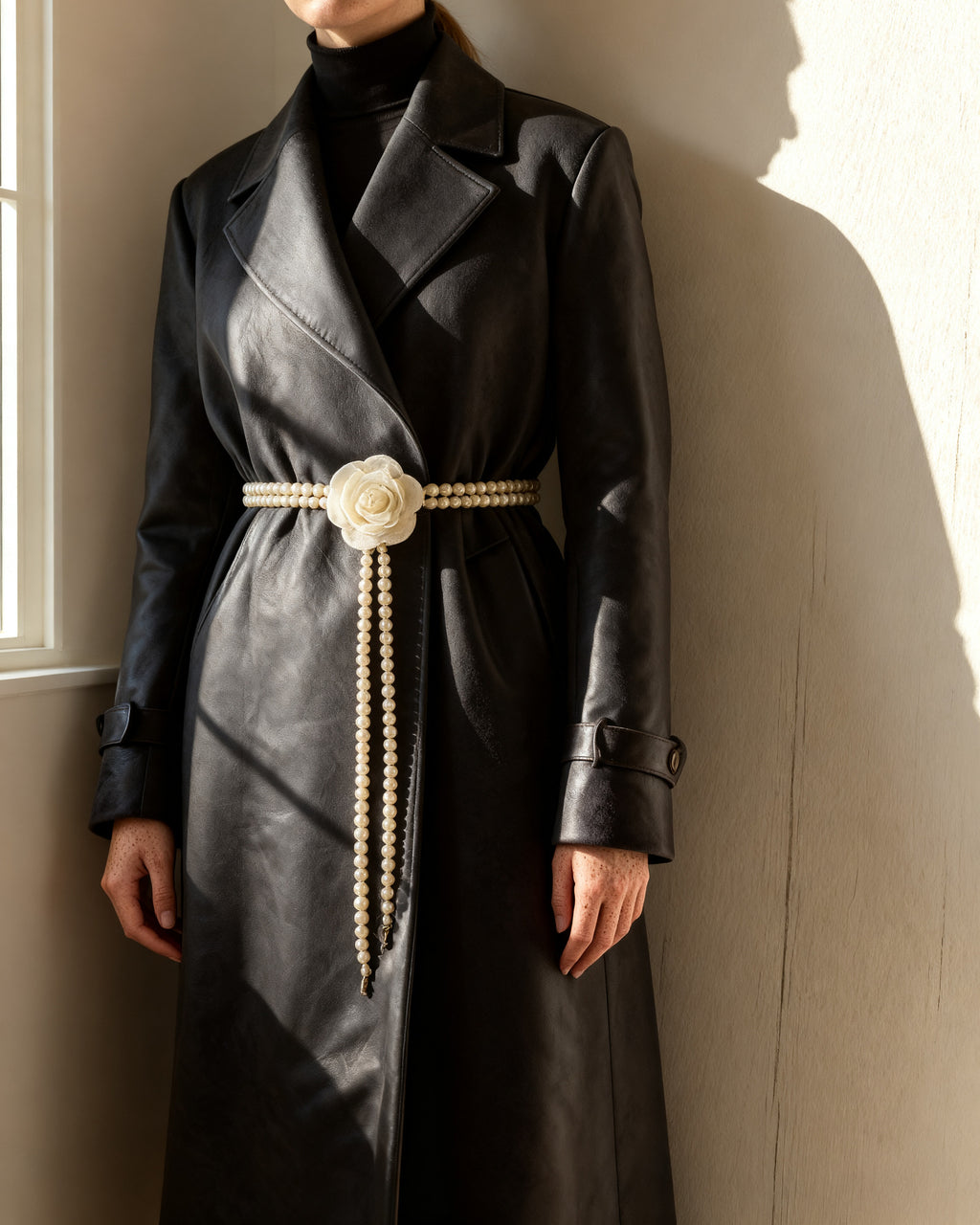 the bloom: the multi-strand faux pearl cord tied over a dark closed coat at the waist