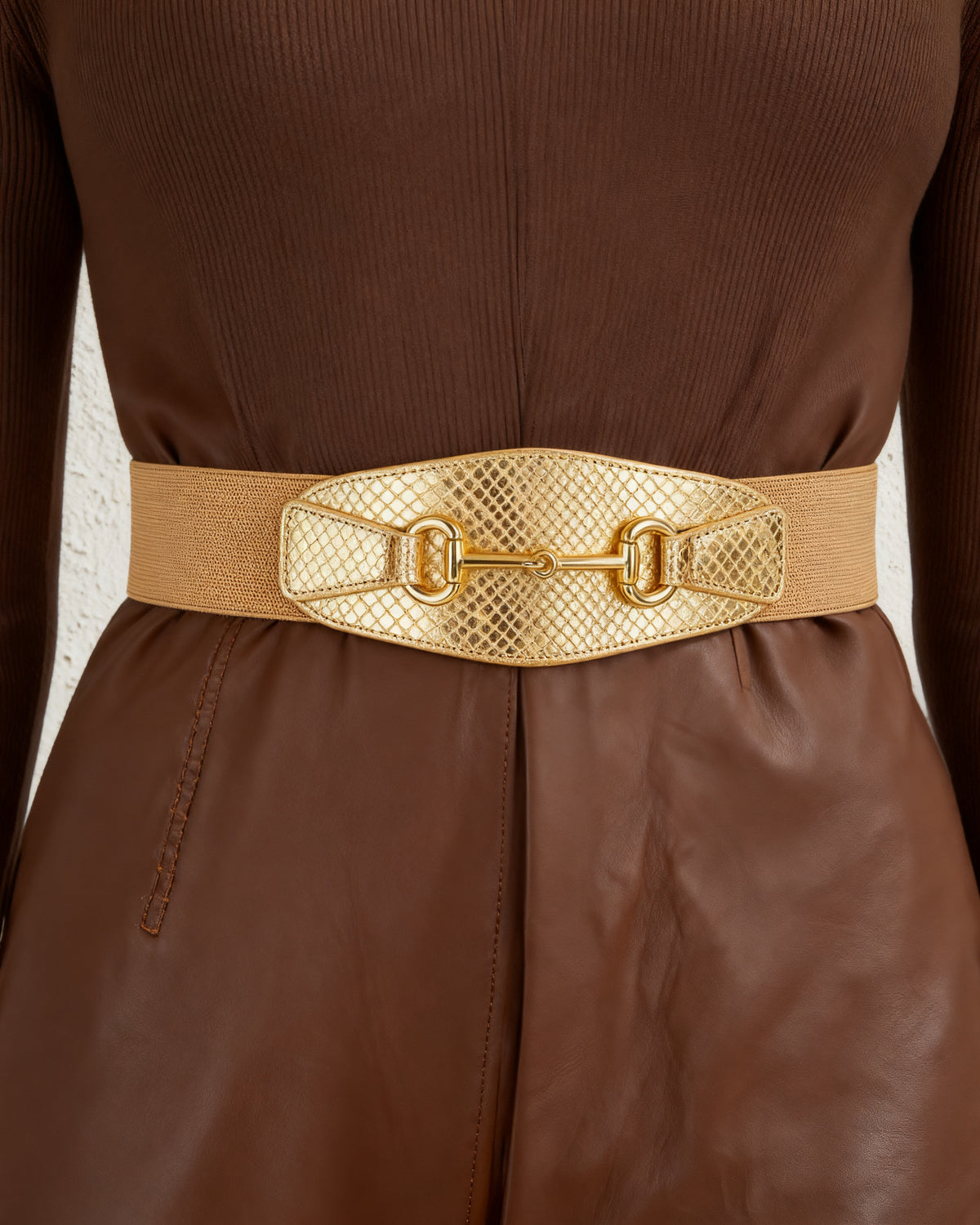 the scale: the wide gold scale belt at the waist of a chocolate leather dress