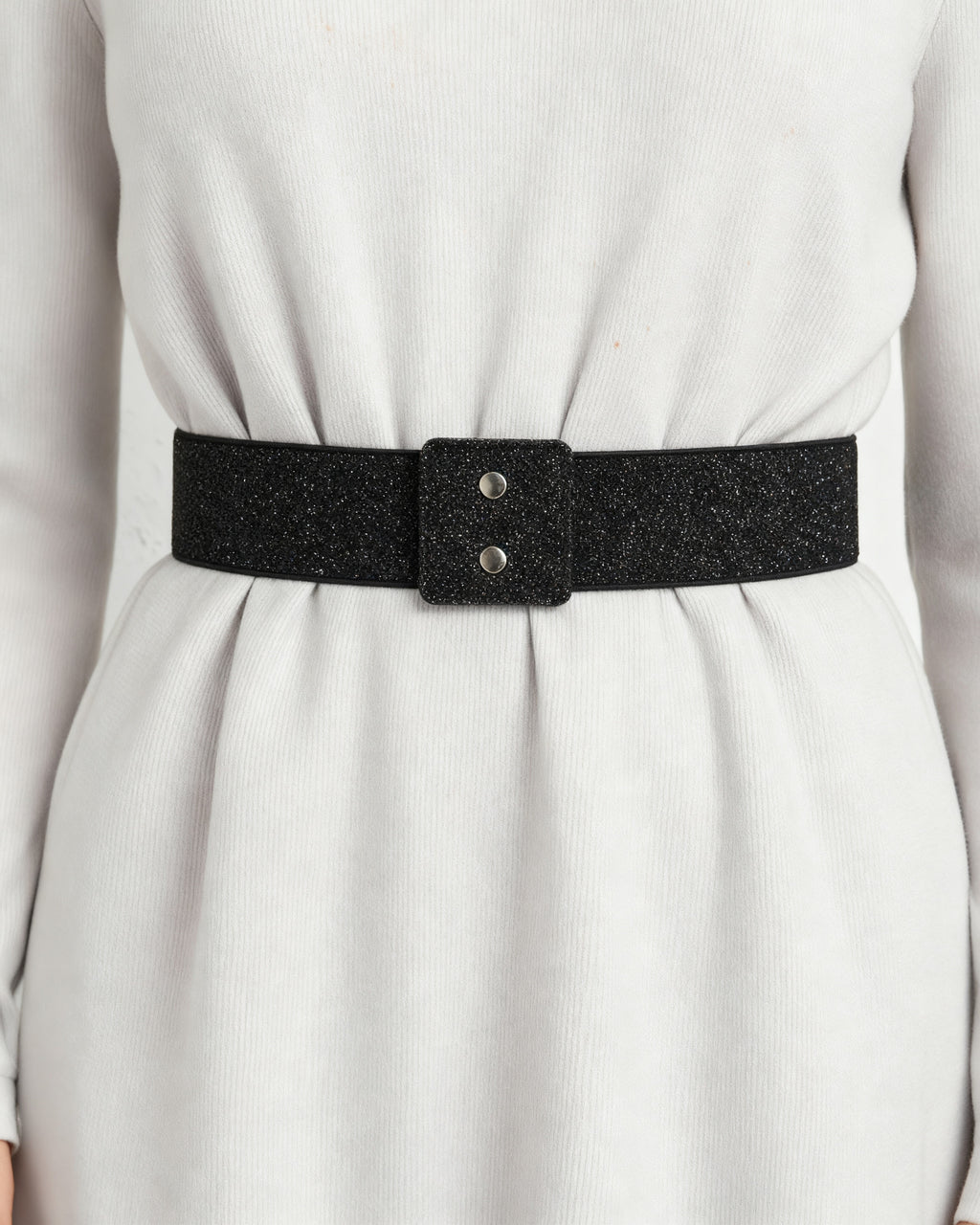 the snap: the wide black glitter waist band at the waist of a pale grey dress