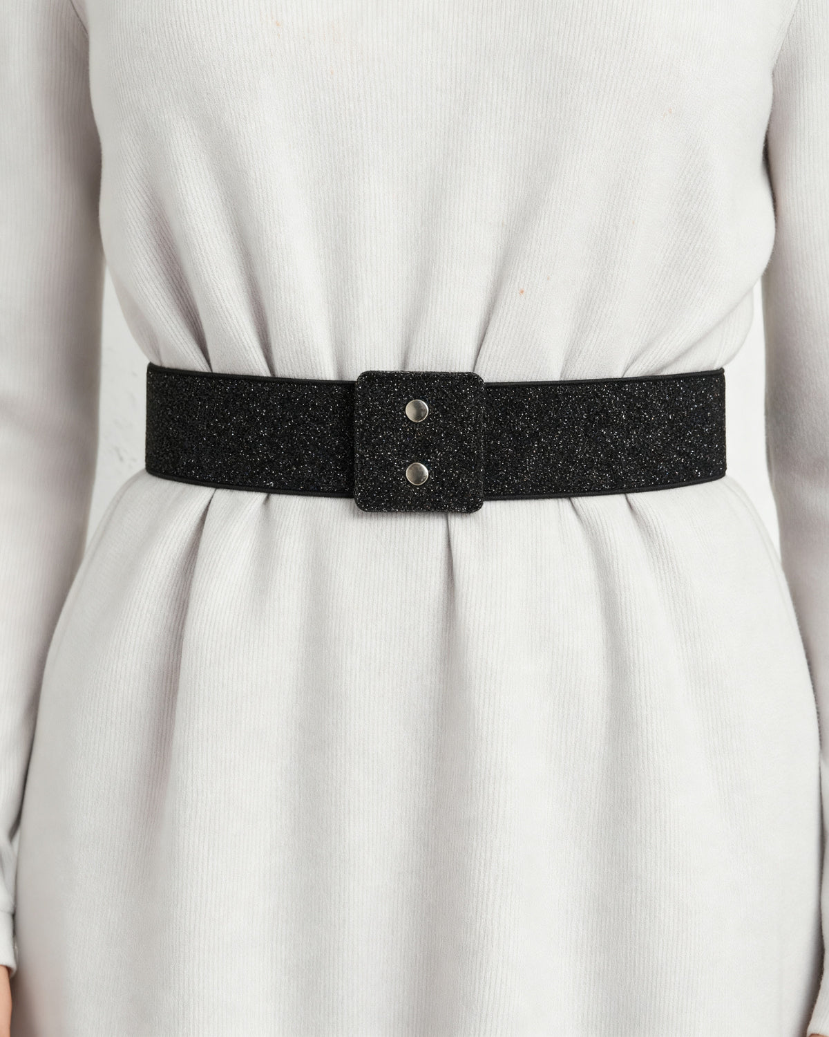 the snap: the wide black glitter waist band at the waist of a pale grey dress