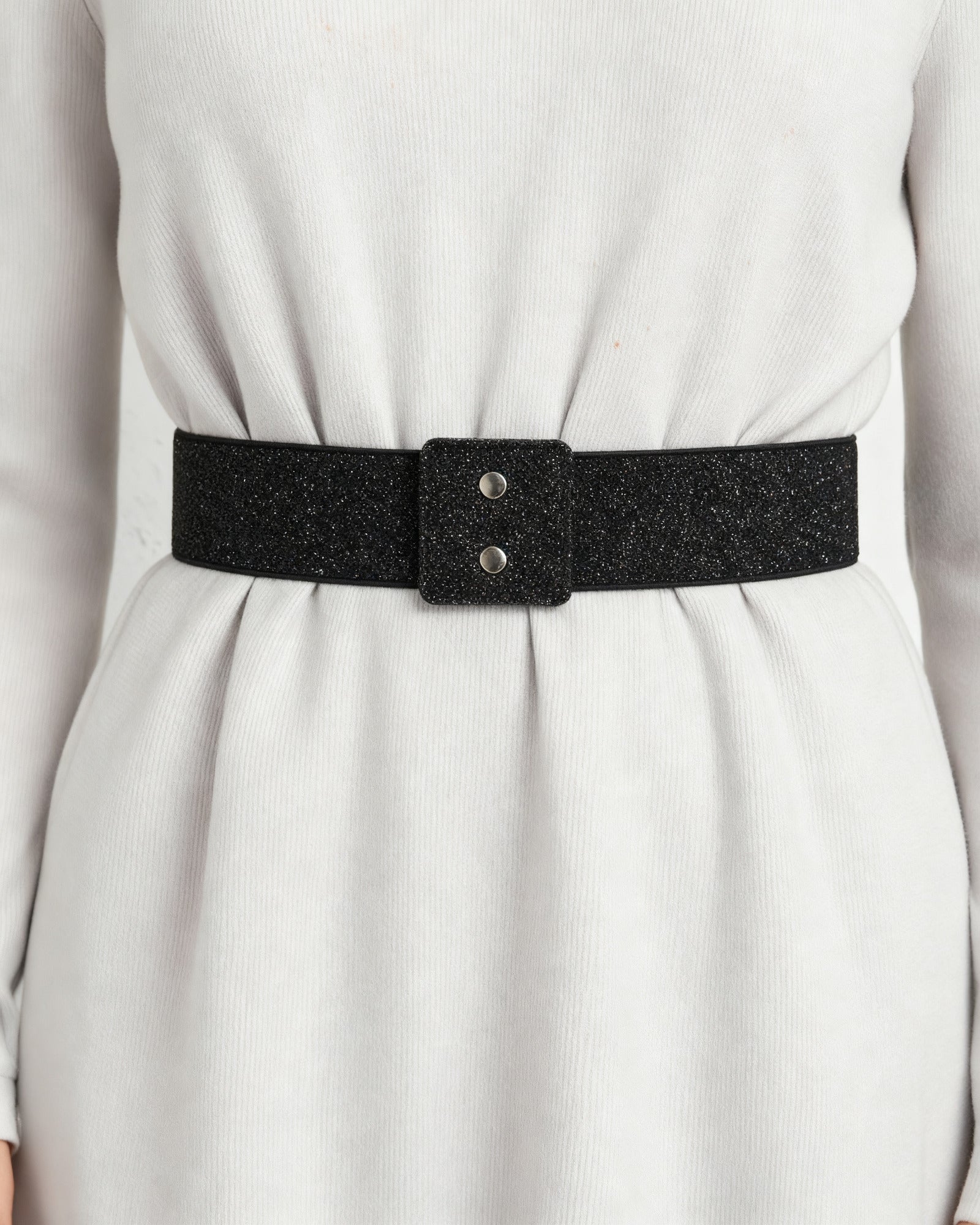 the snap: the wide black glitter waist band at the waist of a pale grey dress