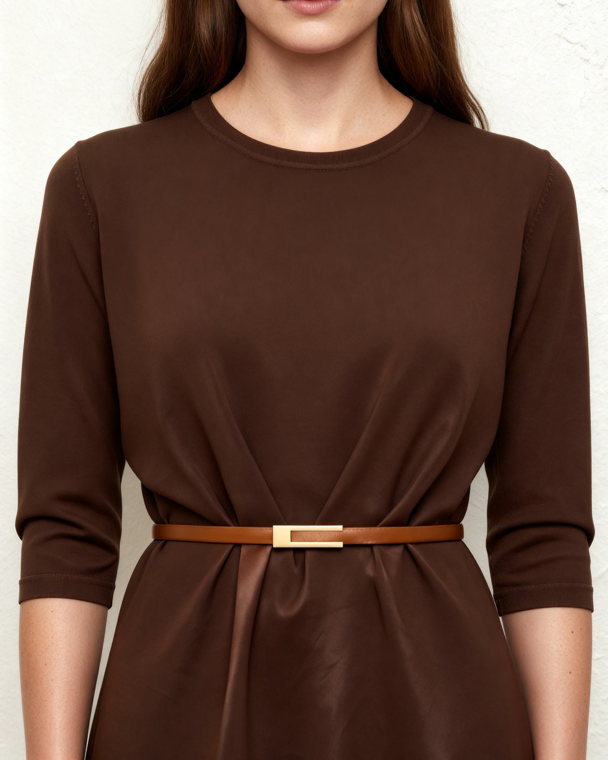 the tab: the thin tan belt cinching a chocolate ribbed dress at the waist